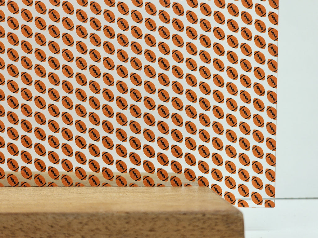 PatternPly® Scattered Orange and Black Footballs sheet showing the pattern
