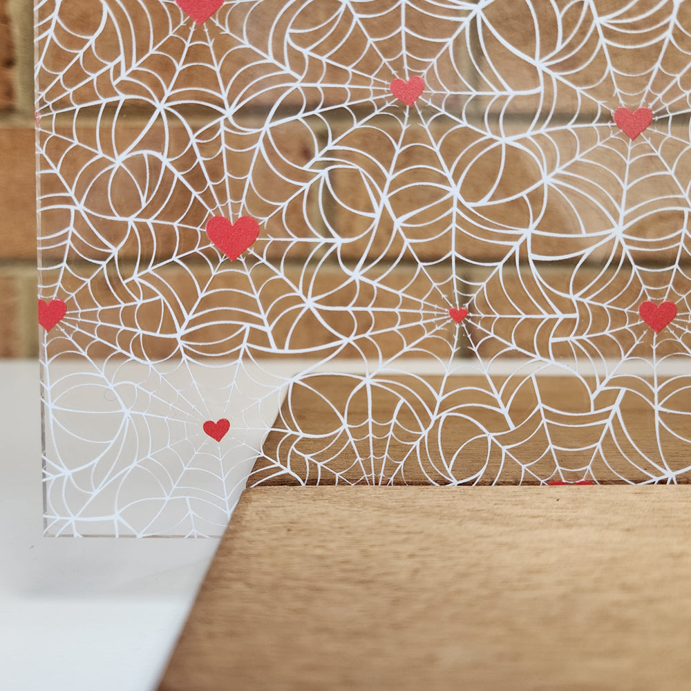 PatternPly® Scattered White Spiderwebs with Red Hearts sheet showing the pattern