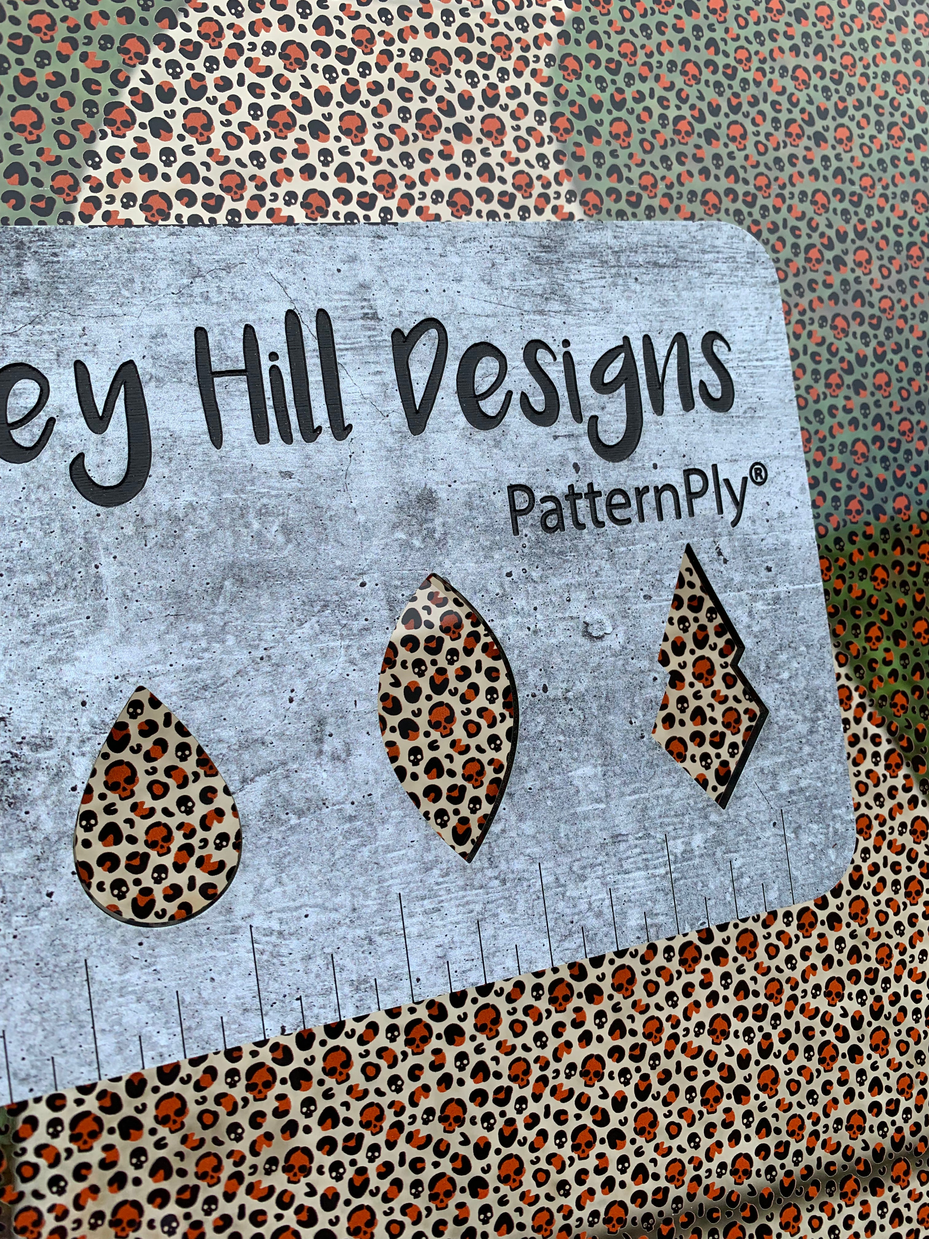 PatternPly® Scattered Orange Micro Skull Leopard sheet showing the pattern